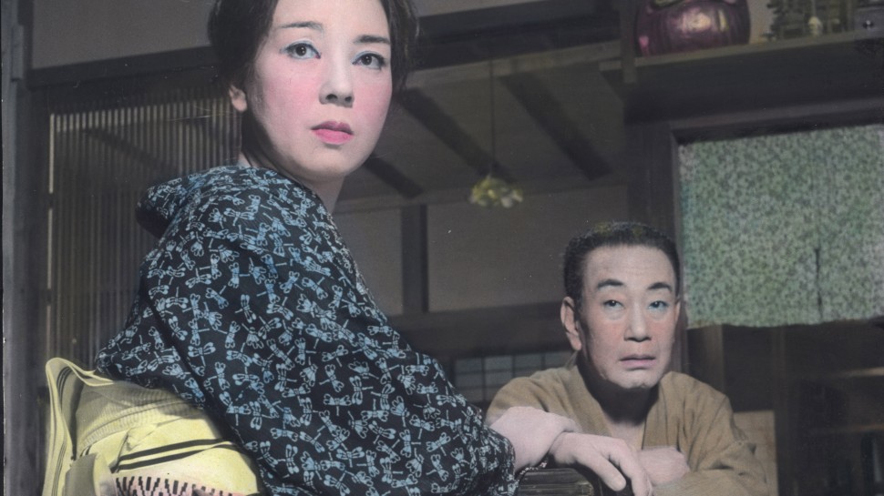 a Japanese man and woman in traditional dress look past the camera with concerned expressionsalr