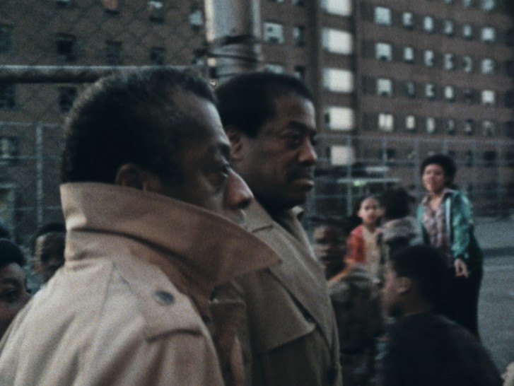 James Baldwin in a city with others around himalr