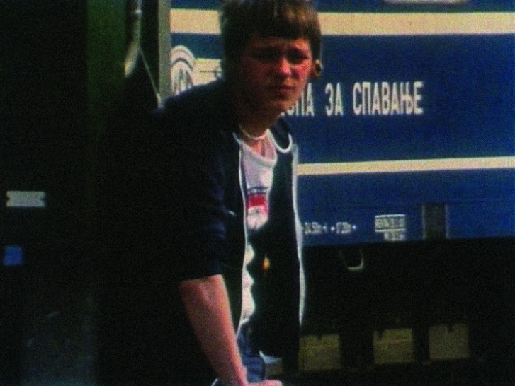 white teenaged boy in a t-shirt and jacket looks out at the cameraalr