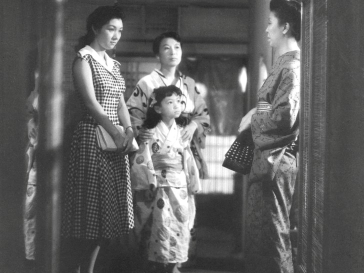 Takamine Hideko, another woman and a little girl stand in a hallway looking somberly at an older womanalr