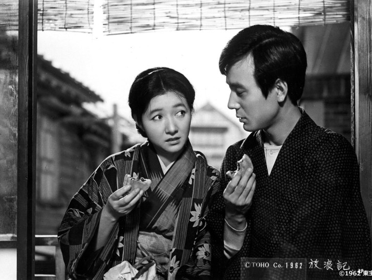 a young Takamine Hideko and Takarada Akira eat cakes and look inquisitively at one anotheralr