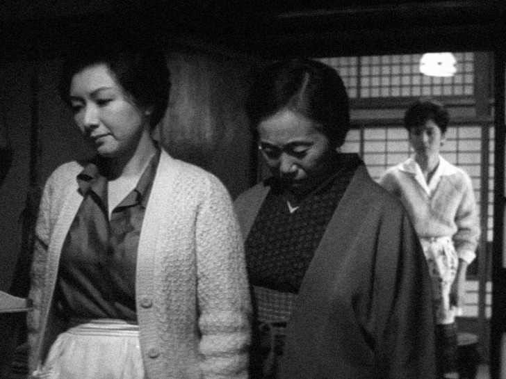 Takamine Hideko and an older woman look sad with their heads down while a woman in the distance looks onalr
