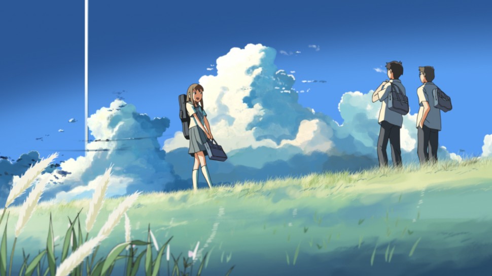 Two boys and one girl with backpacks on a grassy plateau against a blue sky with cloudsalr