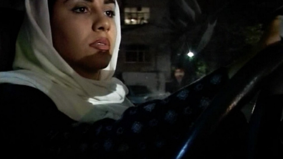 close-up of Iranian woman with veil on driving at nightalr