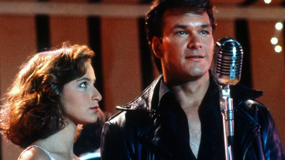 Jennifer Grey and Patrick Swayze on stage in front of a microphonealr