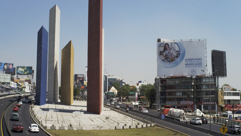 Tall, modernist towers of Luis Barragán's Torres de Satélite in Mexico City with billboard nearbyalr
