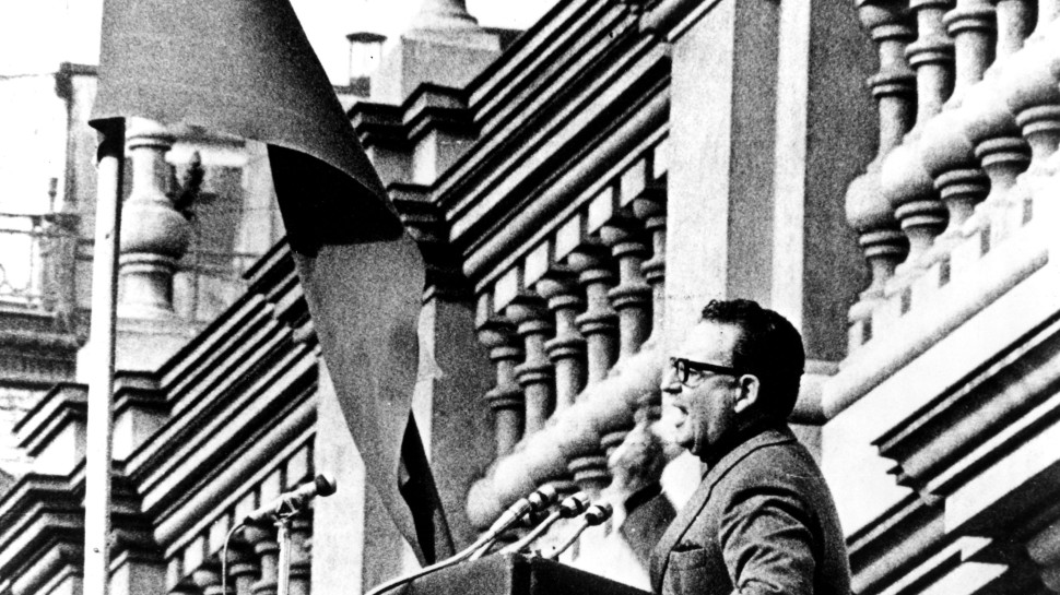 Salvador Allende speaking at a podiumalr
