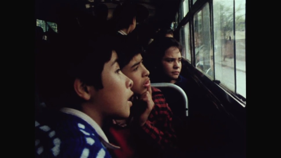 Chilean children look out the windows of a trainalr