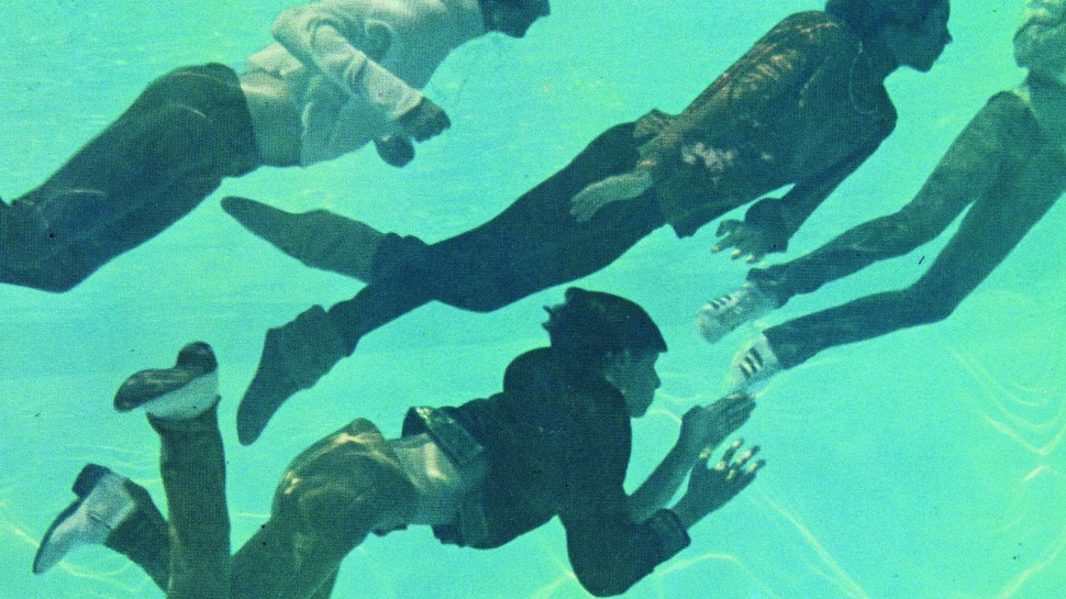 An underwater scene of the band The Monkees swimming in their clothesalr