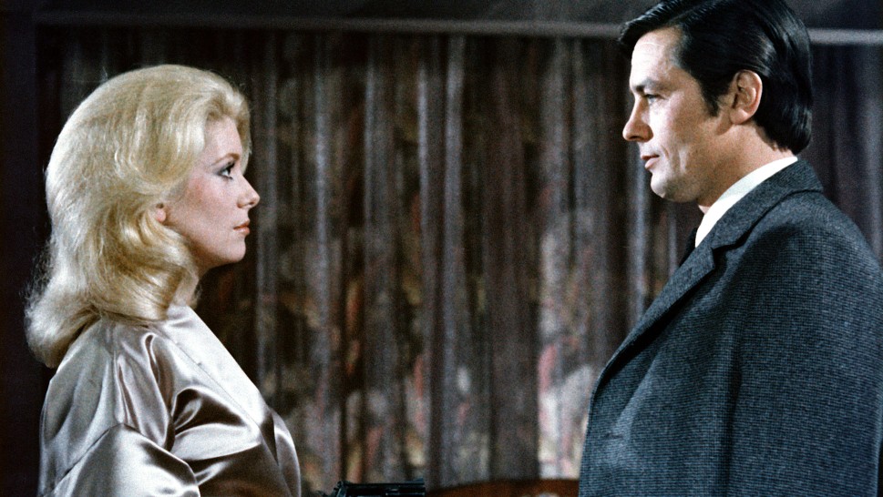 Catherine Deneuve holds a gun to Alain Delonalr