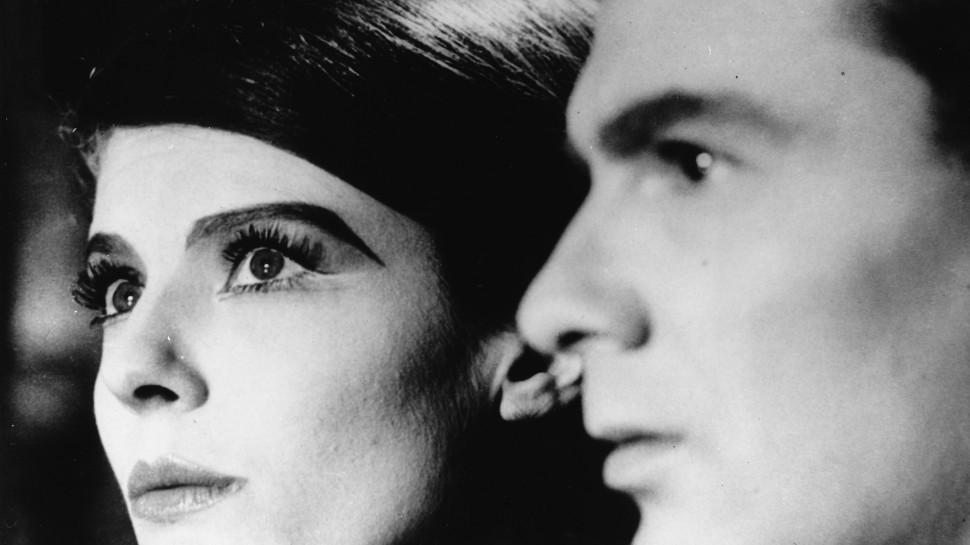 close-up of Delphine Seyrig with dramatic eyeshadow and her male co-staralr