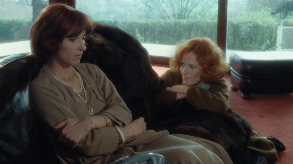 Noëlle Châtelet sits despondently while Delphine Seyrig kneels beside heralr