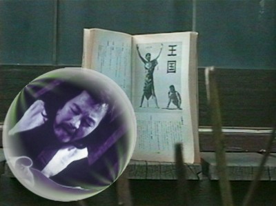 a book showing an image from the film The Kingdom with a man in a little bubble floating in front of it