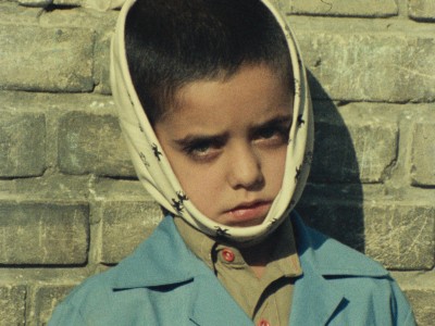 unhappy young boy with a cloth wrapped around his head and face because of a toothache