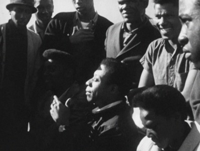 James Baldwin in the middle of teenagers, talking