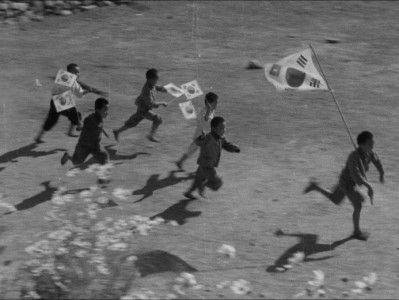 a black and white, artful image of Korean children running with kites