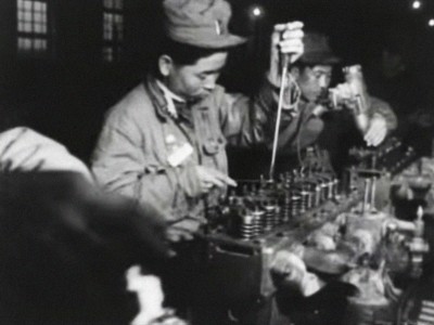 a Korean man working on an assembly line in a truck-manufacturing factory