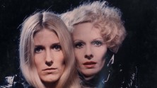 close-ups of blond Danielle Ouimet and glamorous Delphine Seyrig looking at the viewer, dressed in black 