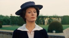 Delphine Seyrig as Aloïse in a hat, walking in a garden